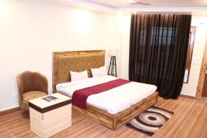 a bedroom with a large bed and a chair at Blest Inn Kasol in Jāmb
