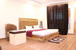a bedroom with a large bed and a chair at Blest Inn Kasol in Jāmb