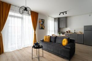 a living room with a couch and a kitchen at Urban Modern Apartment - AFI Arad in Arad +40 photos