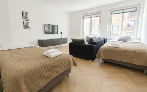 a bedroom with two beds and a couch and a tv at Old Town Apartments in Düsseldorf +67 photos