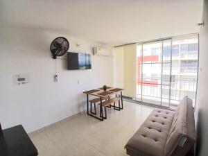 a living room with a table and a couch and a clock at Five Homes Ricaurte in Ricaurte