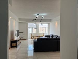 a living room with a black couch and a table at By the Sea in Swakopmund