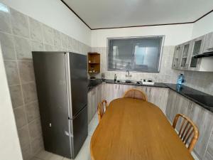 a kitchen with a wooden table and a refrigerator at By the Sea in Swakopmund