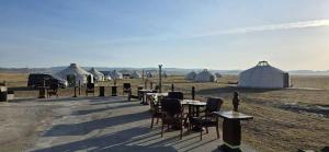 a group of tents in a field with tables and chairs at Nomad equestrian Luxury Ger camp in New Ulaanbaatar International Airport