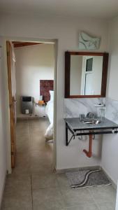 Un baño con un lavabo y un espejo en la pared. en Apart Fincas de San Pablo II, en Deán Funes