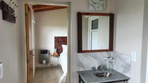 un baño con lavabo y espejo en Apart Fincas de San Pablo II, en Deán Funes