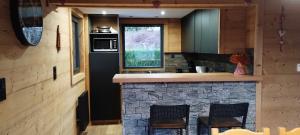 a kitchen with a stone counter with two chairs at Superbe chalet Hautes Vosges in Cornimont +7 photos