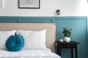 a bed with a blue headboard and a pillow on it at Urban Modern Apartment - AFI Arad in Arad