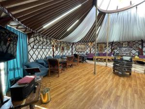 a room with a tent with chairs and a table at Nomad equestrian Luxury Ger camp in New Ulaanbaatar International Airport