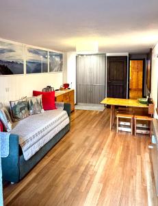 een woonkamer met een blauwe bank en een houten tafel bij Courmayeur La Maison des Amis in Courmayeur