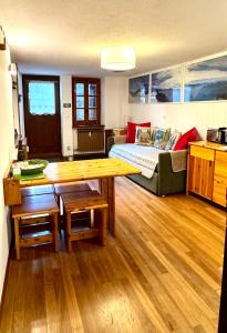 een woonkamer met een tafel en een bed bij Courmayeur La Maison des Amis in Courmayeur