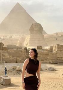 una mujer está parada frente a las pirámides en Noya Pyramids view hotel, en El Cairo
