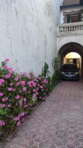 een auto geparkeerd naast een gebouw met roze bloemen bij Córdoba y Colon in Mar del Plata