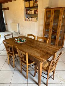 een houten eettafel met stoelen en een tafel bij 70m2 dans une ferme en Isère in Le Pont-de-Beauvoisin