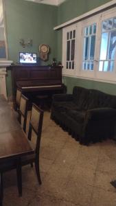 een woonkamer met een piano en een bank bij Córdoba y Colon in Mar del Plata
