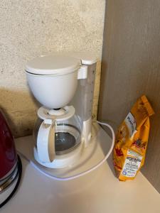 een wit toilet op een aanrecht naast een doos bij 70m2 dans une ferme en Isère in Le Pont-de-Beauvoisin +3 foto's