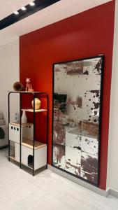 a room with a red wall with a painting on the wall at Abu Rakan Apartment in Muscat +77 photos