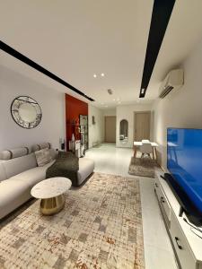 a living room with a couch and a flat screen tv at Abu Rakan Apartment in Muscat