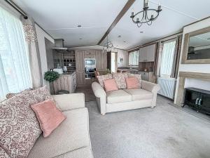 Stunning 8 Berth Caravan With Decking At Kessingland Beach Ref 90017D في Benacre: غرفة معيشة مع كنبتين ومدفأة