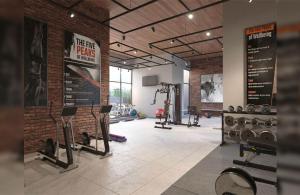 a gym with several tread machines and a brick wall at Departamento Nuevo 1D1B con estacionamiento sobre stripcenter y supermercado in Los Ángeles