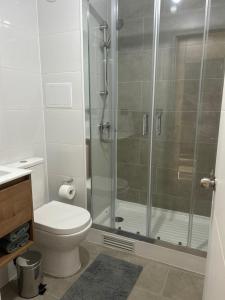 a bathroom with a toilet and a shower at Departamento Nuevo 1D1B con estacionamiento sobre stripcenter y supermercado in Los Ángeles