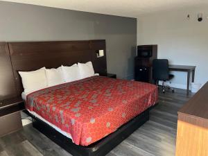 a hotel room with a bed and a desk at Roseville Inn in Roseville