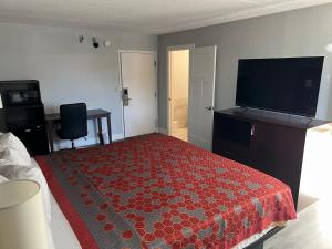 a bedroom with a bed and a flat screen tv at Roseville Inn in Roseville