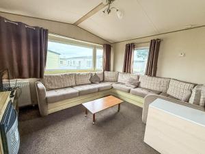 a living room with a couch and a table at 6 Berth Caravan With Side Decking At Suffolk Sands Holiday Park Ref 45054C in Felixstowe