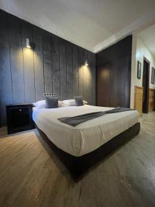 een groot bed in een kamer met een houten muur bij SINGAPOUR MAROC in Casablanca