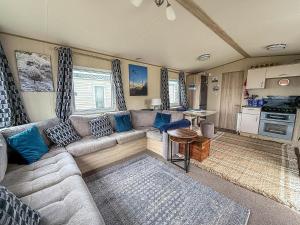 Cosy 6 Berth Caravan With Side Decking At Kessingland Beach, Suffolk Ref 90031Sv في Benacre: غرفة معيشة مع أريكة ومطبخ
