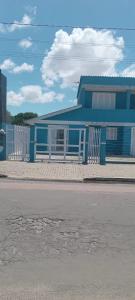 a blue building with a fence in front of it at Aluguel casa azul in Capão da Canoa