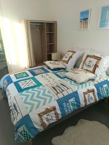 a bed with a quilt on it in a room at T2 a St Nazaire, 500 mètres de la plage in Saint-Nazaire