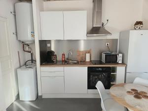 a small kitchen with white cabinets and a table at T2 a St Nazaire, 500 mètres de la plage in Saint-Nazaire