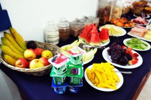 a table topped with plates of fruits and vegetables at Tiradentes Pousada Ramalhete in Tiradentes