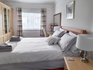 a bedroom with a large white bed and a window at Wheelhouse 21 in Amble +15 photos