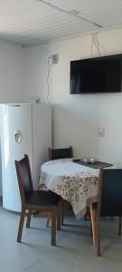 a room with a table and two chairs and a television at Aluguel casa azul in Capão da Canoa