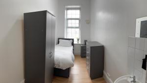 谢菲尔德Wicker guesthouse的一间带床、柜子和窗户的卧室