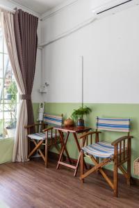 ホーチミン・シティにあるKibou Homestayのダイニングルーム(椅子2脚、木製テーブル付)
