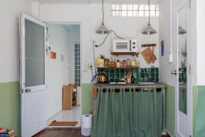 ホーチミン・シティにあるKibou Homestayのシンクと電子レンジのある小さなキッチン +4枚の写真