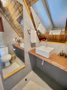 a bathroom with a sink and a toilet and a mirror at Pousada Villa di Luna in São Miguel do Gostoso +95 photos