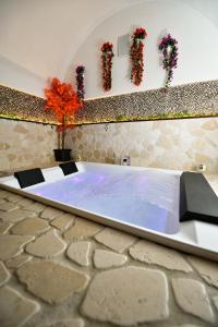 una vasca da bagno in una stanza con fiori su una parete di Eterea Wellness Suites a Montescaglioso