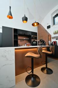 una cucina con un bancone e due sgabelli di Eterea Wellness Suites a Montescaglioso