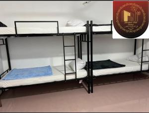 two bunk beds in a room with a sign at international hoste in Muscat
