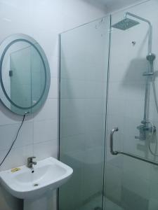 a bathroom with a sink and a glass shower at De Baylux Hotel and Suites, Lekki, Lagos in Maiyegun