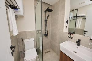a bathroom with a shower and a toilet and a sink at Settle inn Fajr Boutique hotel in Cairo +32 photos