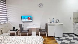 a hotel room with a bed and a table and chairs at Apartman IDEA in Zrenjanin