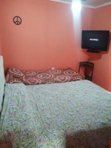 a bedroom with a bed with a television on the wall at Depto San Clemente 3 in San Clemente del Tuyú
