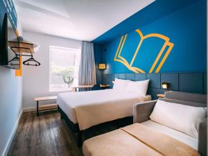 a hotel room with two beds and a couch at ibis Styles Poços de Caldas in Poços de Caldas +93 photos