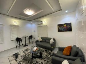 una sala de estar con un sofá y una mesa en Spacious one bed self compound, en Iju Junction