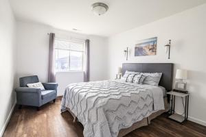 een slaapkamer met een bed, een stoel en een raam bij Canyon View Oasis home in Redlands